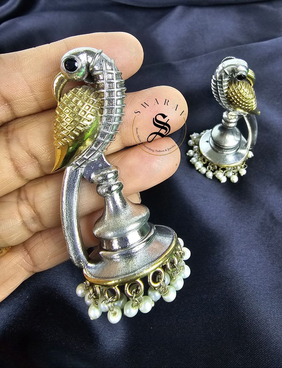 Oxidized swan shape earring in two tone polish.