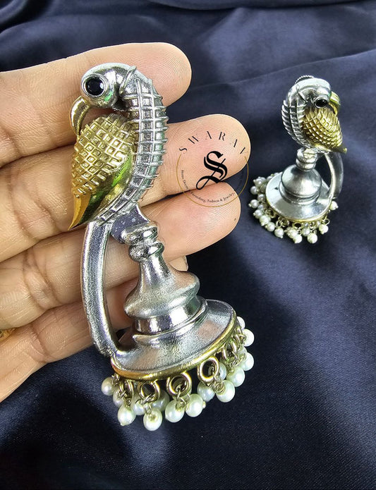 Oxidized swan shape earring in two tone polish.