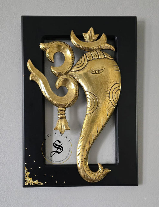 Brass sheet cladding on wood carved Om ganesha figurines. Size 18 by 12 inch. Framed for wall mounting.